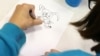 France -- A child draws in the Salle du Pont du Buy