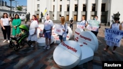 Пациенты и активисты принимают участие в перформансе с требованием декриминализации медицинского каннабиса перед зданием Рады в Киеве, Украина, 13 июля 2021 года