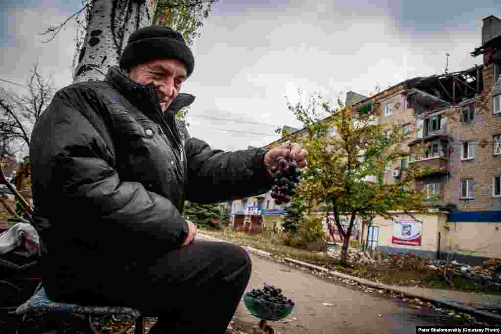 Житель Горловки - Николай - продает виноград, который он выращивает в своем саду. Население возврашается в свои дома, но найти работу очень сложно. Горловка. Украина. Октябрь 2014